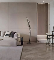 Sculptural designer floor lamp placed beside a sofa in a minimalist interior
