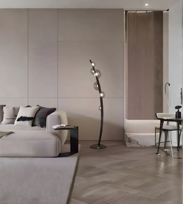 Sculptural designer floor lamp placed beside a sofa in a minimalist interior