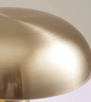 Close-up of brushed gold dome shade table lamp