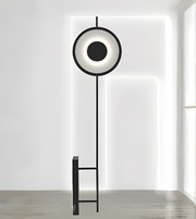 Modern circular LED floor lamp with black metal frame in minimalist interior