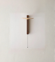 Minimal modern wall sconce with pull chain mounted on a neutral wall