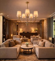 Linen fabric shade brass chandelier illuminating a luxury living room with warm ambient lighting