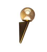 Wall-mounted light fixture with a glass globe on a white background