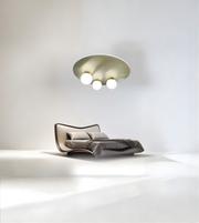 Minimalist bedroom featuring brass disc flush mount ceiling light with opal globe shades