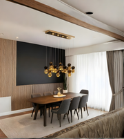 Modern dining room with a chandelier, wooden table, and gray chairs.