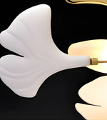Modern wall sconce with white ceramic shade and gold fixture on a black background