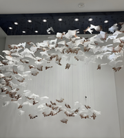 Artistic installation of white and brown birds on a ceiling