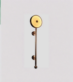 Decorative wall light fixture with a gold finish on a light gray background