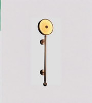 Decorative wall light fixture with a gold finish on a light gray background