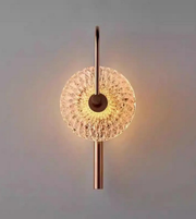 Wall-mounted light fixture with decorative glass shade on a plain background