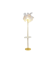 White floor lamp with gold base on a white background