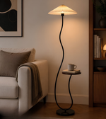 Modern floor lamp with a round table in a living room setting.