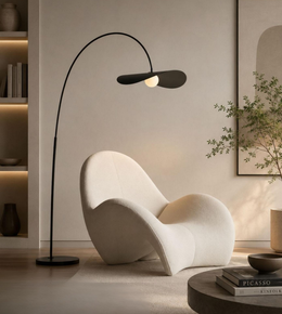 Modern black floor lamp next to a white chair in a stylish room.