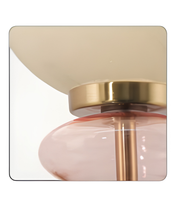 Decorative wall sconce with gold and pink design on a white background