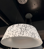 Speckled patterned pendant light fixture on a dark ceiling