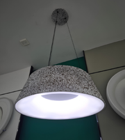Modern pendant light with speckled gray shade on a white ceiling