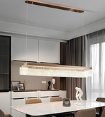 Modern dining room with a long rectangular pendant light fixture.