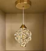 Decorative pendant light with crystal details on a beige wall background