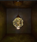 Decorative ceiling light fixture with intricate design in a dimly lit room.
