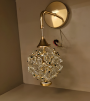 Decorative wall light fixture with crystal ball design on a neutral background