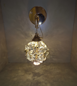Decorative wall light fixture with crystal ball design on a plain wall.