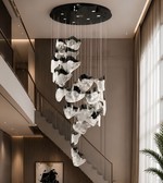 Modern chandelier hanging in a stylish interior setting with a staircase and window.