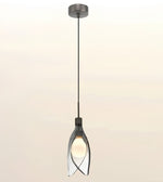 A modern pendant light with a dark gray metal canopy and cord, featuring a clear glass shade with a glowing warm bulb inside, set against a soft beige gradient background.