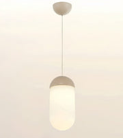 A modern pendant light with a frosted cylindrical shade and a matte beige cap and ceiling mount, shown against a plain off-white background.