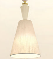 A modern pendant light fixture with a tapered beige linen-textured shade, a white geometric neck, and a gold-toned metal cap, shown against a plain off-white background.