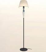 A modern floor lamp with a black metal stand, a round base, a tapered beige fabric shade, and decorative glass accents in the center.