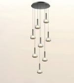 A modern multi-light linear chandelier with seven cascading glass shades and brushed metal accents, shown against a plain light beige background.