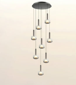A modern multi-light linear chandelier with seven cascading glass shades and brushed metal accents, shown against a plain light beige background.
