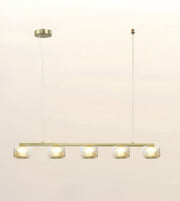 A modern linear chandelier with five clear glass shades and warm white LED lights, suspended from a slim cable with a round canopy on a plain off-white background.