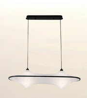 A modern pendant light fixture with a wide, curved white shade and a black top bar and suspension cords, shown against a plain light beige background.