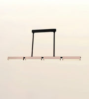 A modern linear LED pendant light with a matte black frame and horizontal bar, suspended against a plain off-white background.