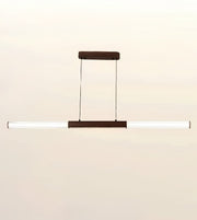 A modern linear pendant light fixture with a horizontal white ribbed glass tube and dark brown metal accents, suspended against a plain light beige background.