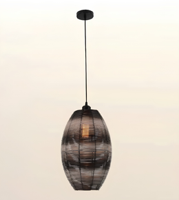 A hanging pendant light with a dark metal frame and a warm glowing bulb inside, suspended against a plain light background.
