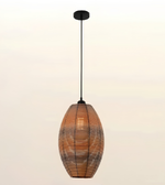 A modern pendant light with a warm-toned woven rattan or wicker shade, suspended by a slim black cord from a black ceiling canopy against a soft, light beige gradient background.