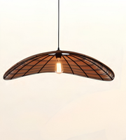 A modern pendant light with a curved, fan-like shade made of dark metal and warm brown wood slats, featuring a glowing Edison bulb in the center, suspended against a plain off-white background.
