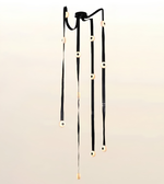 Contemporary cascade LED strap chandelier with illuminated circular light modules for staircases, foyers, double-height living rooms, and luxury interiors.
