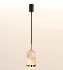 A modern pendant light with a black cylindrical ceiling canopy, a slim black cord, and a warm white marble shade with gold-toned metal accents.