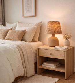 Natural cork table lamp with ceramic-style base creating warm ambient lighting in a modern bedroom.