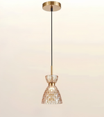 A modern pendant light fixture with a brushed gold ceiling canopy and downrod, a black cord, and a tapered glass shade made of small mosaic tiles.