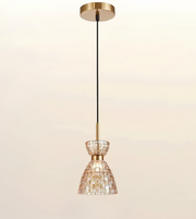 A modern pendant light fixture with a brushed gold ceiling canopy and downrod, a black cord, and a tapered glass shade made of small mosaic tiles.