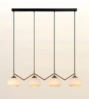 A modern 4-light linear pendant chandelier with a matte black top bar and arms, and warm white frosted glass shades, shown against a light beige gradient background.