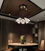 Modern dining room with a stylish chandelier, round table, and chairs.