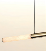 A modern linear pendant light with a cylindrical frosted glass shade and a brushed brass metal tube, suspended by a thin black cord against a plain off-white background.