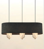 A modern linear pendant light with a wide, dark charcoal gray fabric drum shade and three hanging marble-style glass shades below, shown against a plain off-white background.