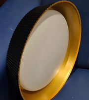 Round light fixture with gold rim on a blue background