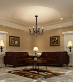 Living room with brown leather sofa, chandelier, and framed artwork on beige walls.